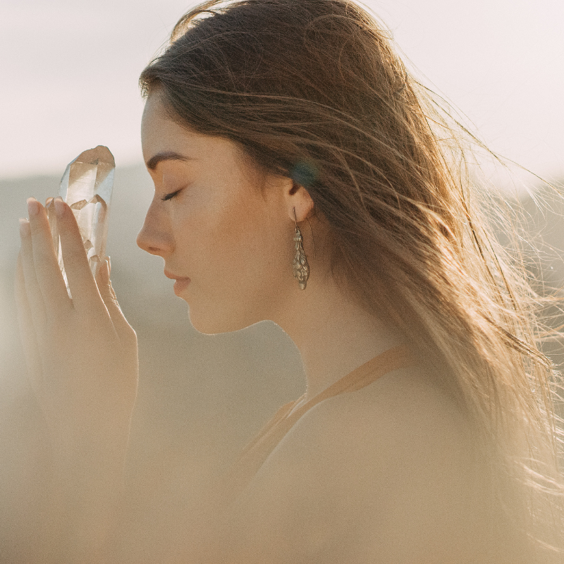 Woman with healing crystal on mountain top